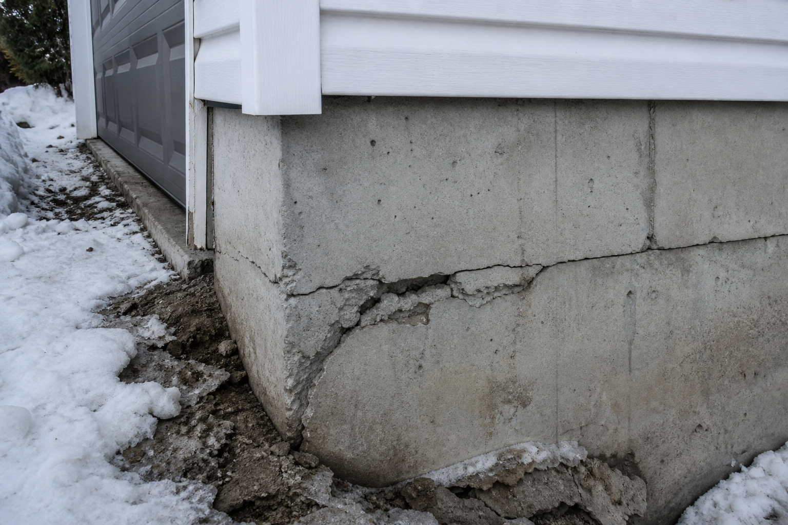 Frost heave crack at grade on a concrete foundation in winter
