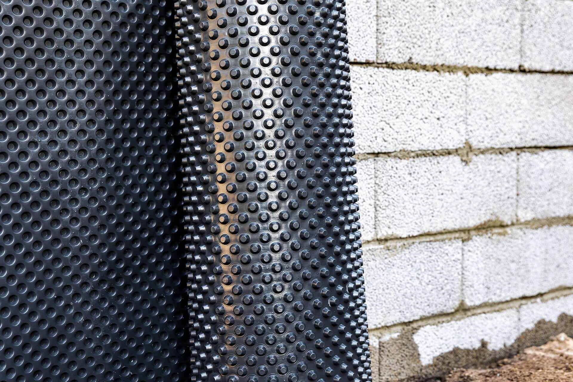 basement wall waterproofing - installing dimple geomembrane